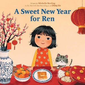 a young girl with dark hair wearing a red and orange dress is standing behind a table decorated in sweet foods and lanterns