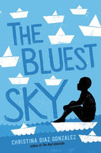 a boy in sihloutte is sitting on a paper boat surrounded by other boats that are white against a blue sea and sky