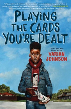 A young Black Boy shuffling cards