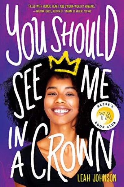 A young Black woman stands proudly and smiles at the camera. There is a drawing of a crown on her haid.