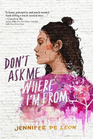 a girl with dark wavy hair wearing a pink top which has a skyline towards the bottom is looking over her shoulder. The image is like a mural painted on a brick wall