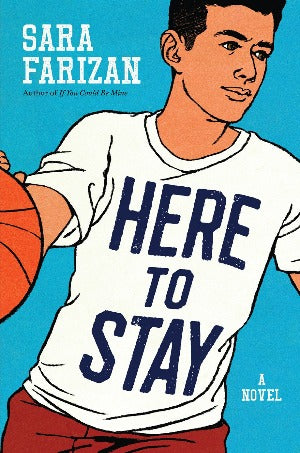 a young man with light brown and black hair is wearing a white t-shirt with the book title here to stay written on it, and holding a basketball as if he's mid-play