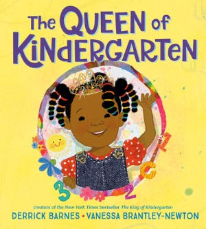 a young black girl with beads in her hair, wearing a red polka dot t-shirt and blue jean pinafore, is waving and smiling. She has her crown on!