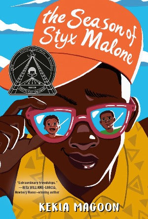 a young black teenager wearing an orange baseball cap and sunglasses is reflecting the images of 2 younger black boys