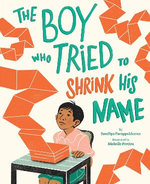 a young boy is sitting a desk. folded up and expanded around the cover is orange paper which is concertinered on the desk but expanded around.
