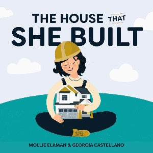 A woman wearing a hard hat and overalls is holding a house while seated